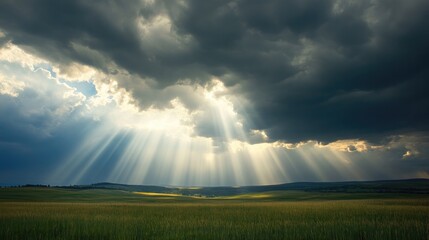 A shot of sunlight breaking through storm clouds, casting dramatic rays of light across a landscape
