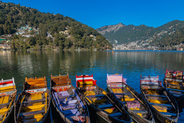 Boats tied at the banks of the famous Naini lake in Nainital, a preferred summer tourist in India. Clicked on 2 January 2022.
