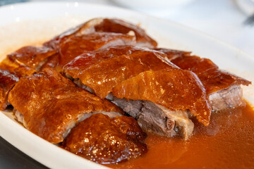 Delicious roasted golden goose is cut into pieces and placed on a plate