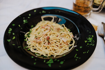 Spaghetti carbonara on a black plate
