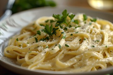 A plate of creamy fettuccine Alfredo garnished with parsley and Parmesan cheese