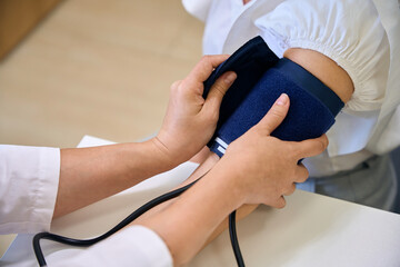 Therapist measures blood pressure of a middle-aged patient