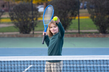 The Tennis. Kid with tennis racket and tennis ball playing on tennis court.
