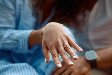 Close up of woman's hand with engagement ring.