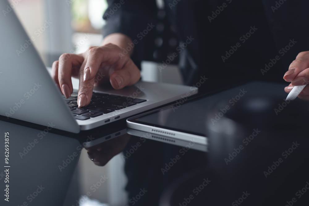 Wall mural close up of business woman hand typing on laptop computer and using digital tablet on office desk, s