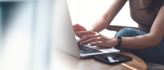 Woman hands typing on laptop computer keyboard, online working, surfing the internet at home office. Casual business woman busy working at coffee shop, close up, freelance lifestyle