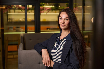 Young beautiful woman sits in relaxation area of coworking space