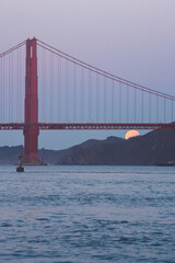 Golden Gate Bridge with a rising moon over the calm San Francisco Bay