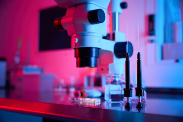 Lab microscope surrounded by red and blue ambient light