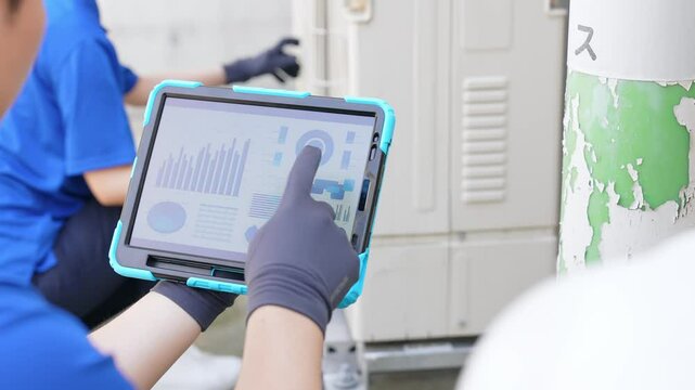 タブレットを見ながら配管・機械を点検するエンジニアのグループ
