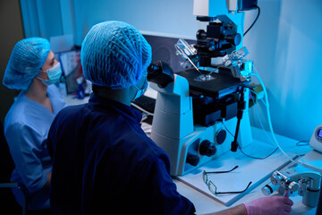 Adult doctors collaborating during a micro-manipulation procedure