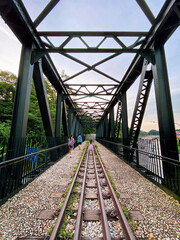 Fototapeta premium Symmetrical Perspective View of Singapore Old Steel Railway Bridge with Train Tracks and Hikers