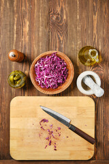 Overhead view of tabletop with red cabbage and pickled cucumbers
