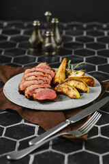 A perfectly seared duck breast surrounded by tender, caramelized apple and pear slices in a plate