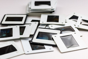 A pile of colour and black and white photo slides isolated in a white background.