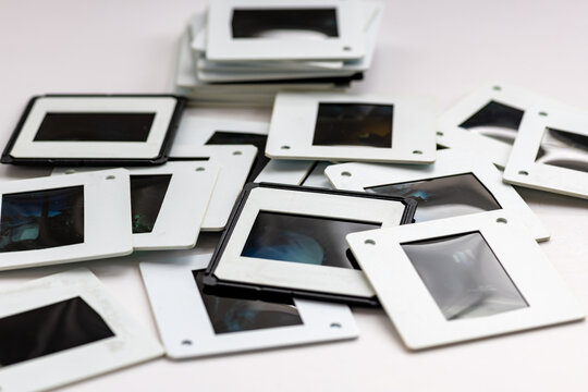 A pile of colour and black and white photo slides isolated in a white background.