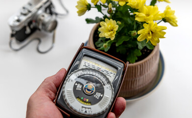 A person using a vintage photography light meter on a subject to obtain the correct exposure time...