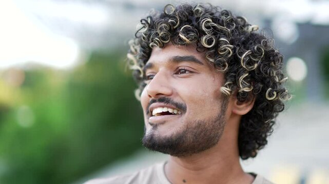 Close up of young man with curly hair closed eyes take a deep breath in outdoor environment. Expression of relaxation, tranquility, mindfulness enjoying fresh air. essence of calm serenity in nature