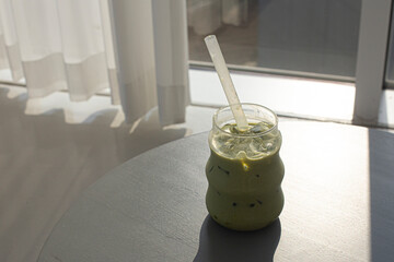 iced matcha green tea latte with milk layer in glass