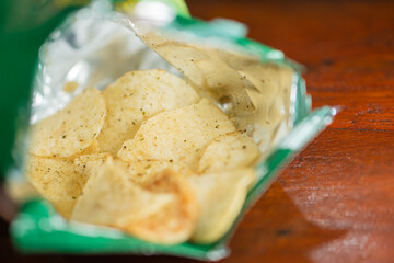 Open Bag of Potato Chips on Wooden Table