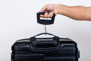 Using a portable hand held digital scale to weigh in carry-on baggage or luggage bag.