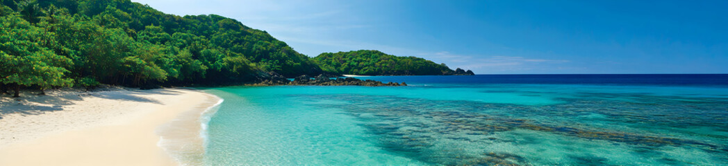 A sweeping view of a tropical coastline with crystal-clear waters gently lapping at a pristine white sandy beach, surrounded by lush greenery under a cloudless sky