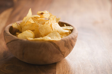 organic potato chips with herbs in bowl on wood table