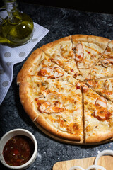 flatlay pizza with sweet and sour sauce, smoked chicken and pickled onions, fresh pizza on a wooden board, tomato sauce, olive oil and soy sauce, lunch, pizzeria