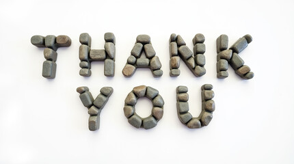 Thank you spelled with river rocks on white background
