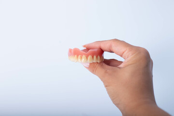 Dental prosthesis in the hands of the doctor close-up.