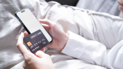 Close up female hands holding credit card and smartphone, young woman paying online, using banking service, entering information, shopping, ordering in internet store, doing secure payment
