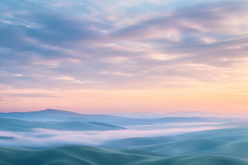 Fototapeta premium A serene landscape at dawn, featuring rolling hills shrouded in mist under a pastel sky.