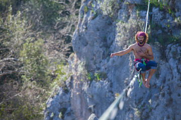Obraz premium A tightrope walker walks along a cable stretched over a canyon.