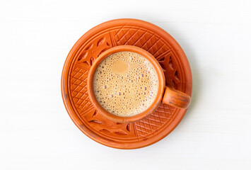 Hot milk tea or dudh cha served in a natural clay cup. Top view.