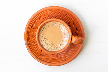 A cup of hot Milk tea or Dudh Cha in a traditional natural clay cup. Top view.