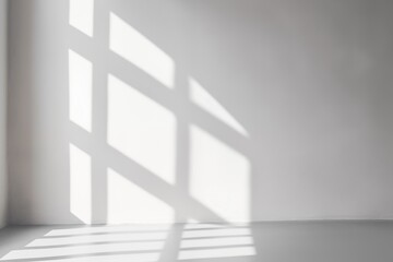 Obraz premium Diagonal window shadow casted by sunlight on white wall.