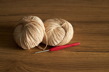 two skeins of yarn for knitting and hook on the table 