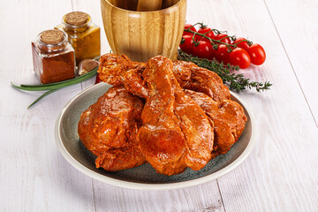 Raw turkey shoulder wing in Indian tandoori marinade
