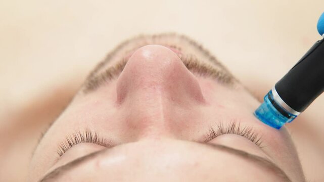 A man undergoes hydrofacial vacuum facial cleansing, rejuvenation, moisturizing facial procedure in a beauty clinic. Beauty and youth concept