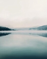 Naklejka premium Lakeside Mountain Landscape in the Early Morning Light with Calm Water Reflections