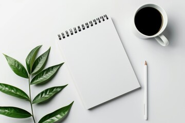 Blank Notebook with Coffee  Pencil and Green Leaf on White Background