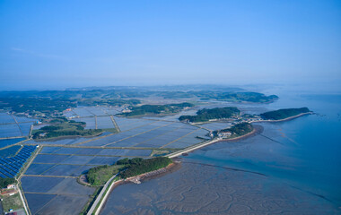 Anmyeondo Island, Taean-gun, Chungcheongnam-do, South Korea - May 23, 2020: Aerial view of of collecting plates of solar power plant and rice fields of reclaimed land at Daeyado Island