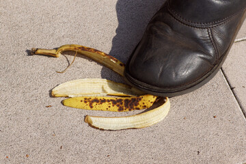 Shoe, slipper, foot on a banana peel on the tiles. Summer, September, Netherlands.