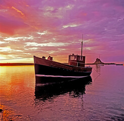 Fototapeta premium Colourful dawn at the small harbour at Lindisfarne Holy Island Northumberland