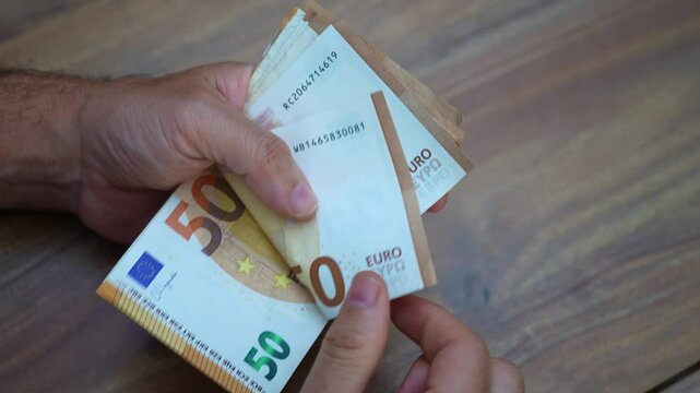 Franchise owner counts euro banknotes from franchise royalties expanding brand presence and implementing growth strategies to capitalize on consumer demand across Europe