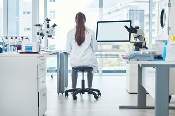 Naklejka premium Science, space and woman in laboratory with computer screen for vaccine development in medical study. Biotech engineer, technician or scientist in research for pharmaceutical innovation from back