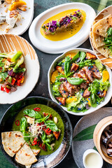vibrant spread of assorted dishes including fresh salads, grilled meats, and tacos, arranged on a...