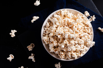 Food concept popcorn in ceramic bowl on black background with copy space