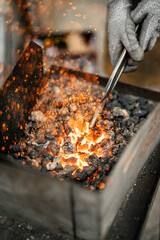 a blacksmith working in a furnace, closeup, ambers