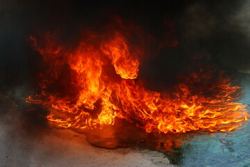Fire and thick smoke spread over the spilled liquid fuel